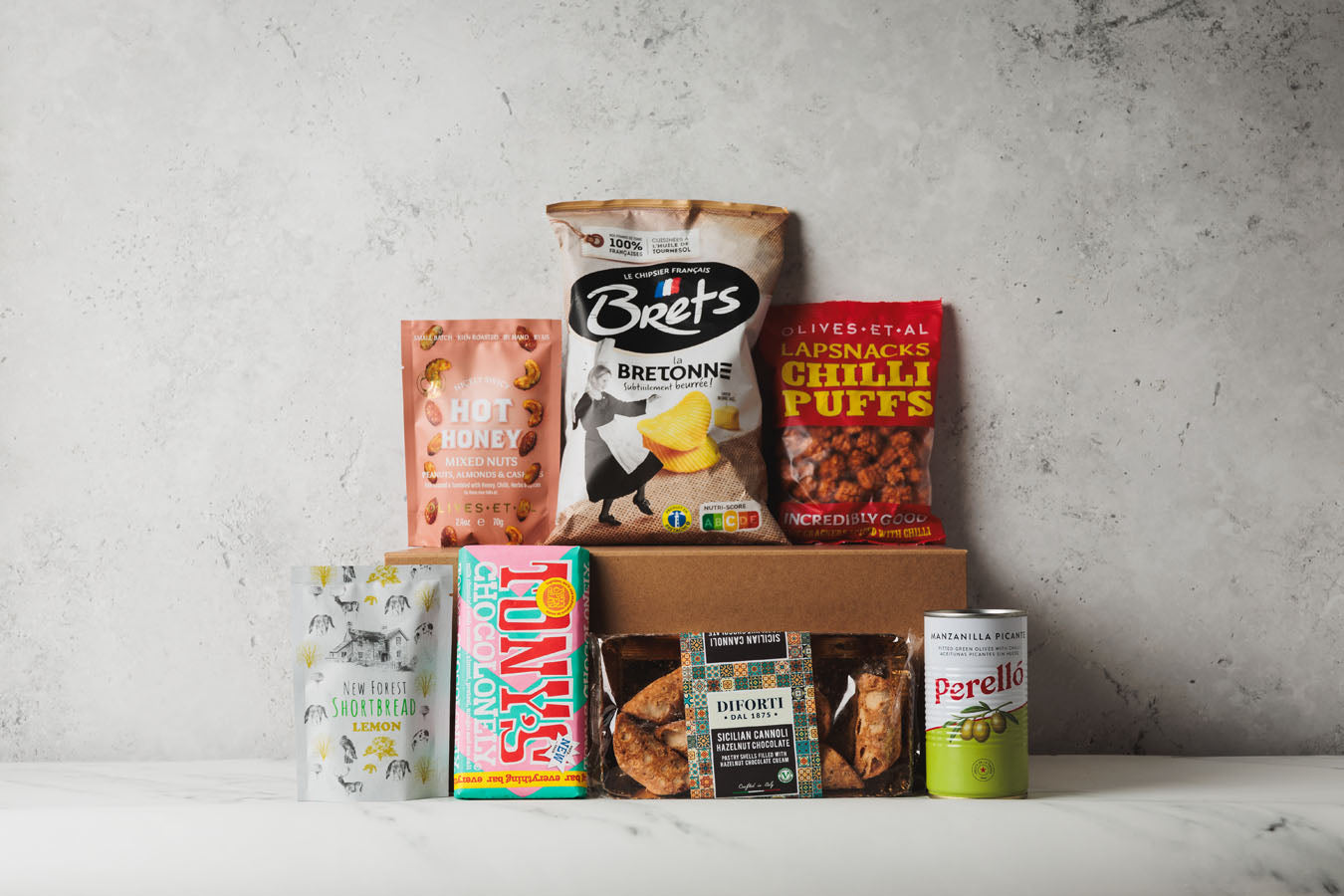 Assorted snack packages on a gray surface with a neutral background